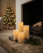 Styled illustration: cream flickering pillar candles grouped on a stone hearth with a Christmas tree behind