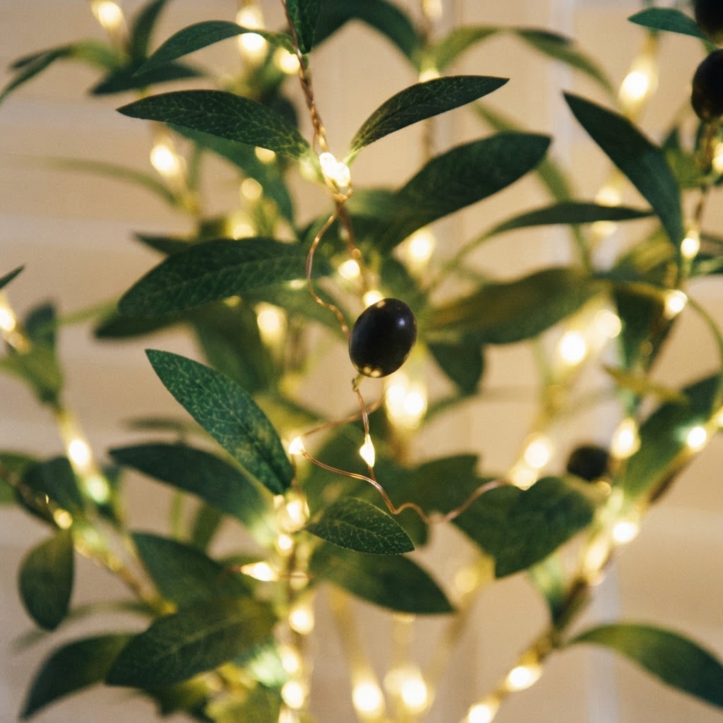 Styled illustration: close-up of warm-white LEDs wound along a faux olive stem among the leaves